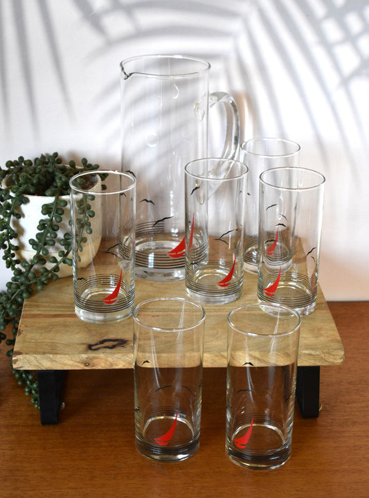 Glass pitcher and 6 matching tumblers with a nautical sailboat design.