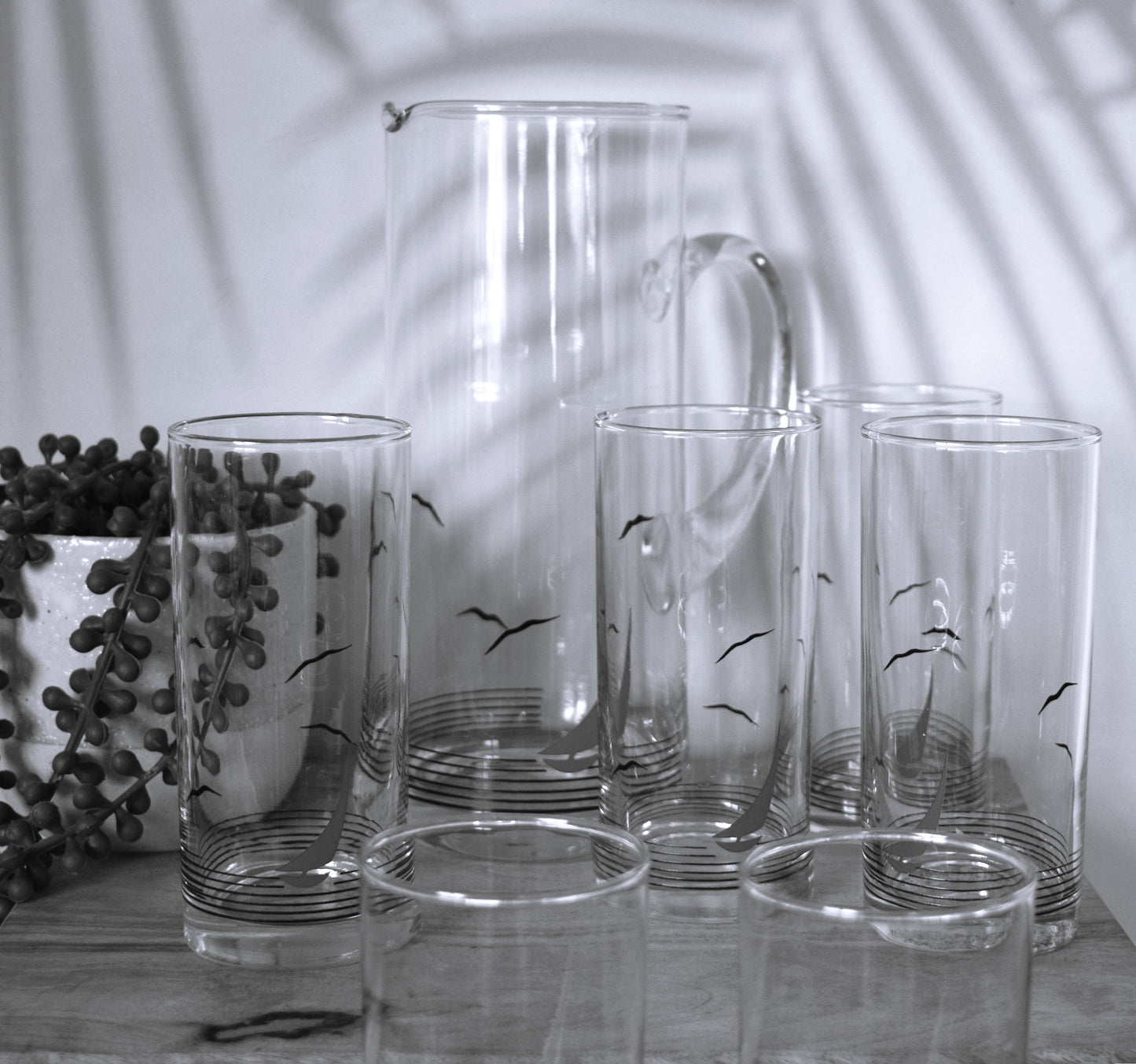Glass pitcher and 6 matching tumblers with a nautical sailboat design.