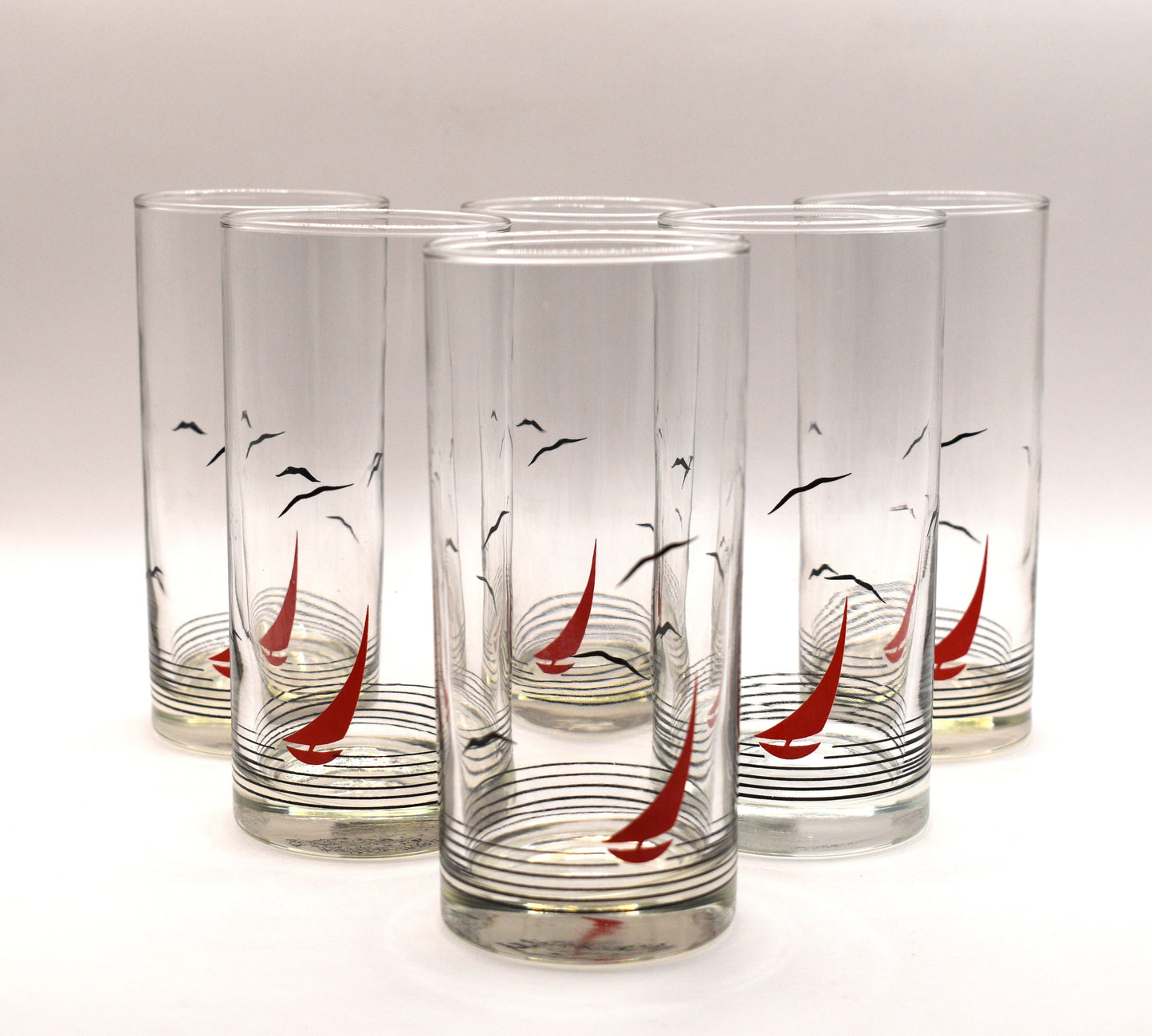 Glass pitcher and 6 matching tumblers with a nautical sailboat design.