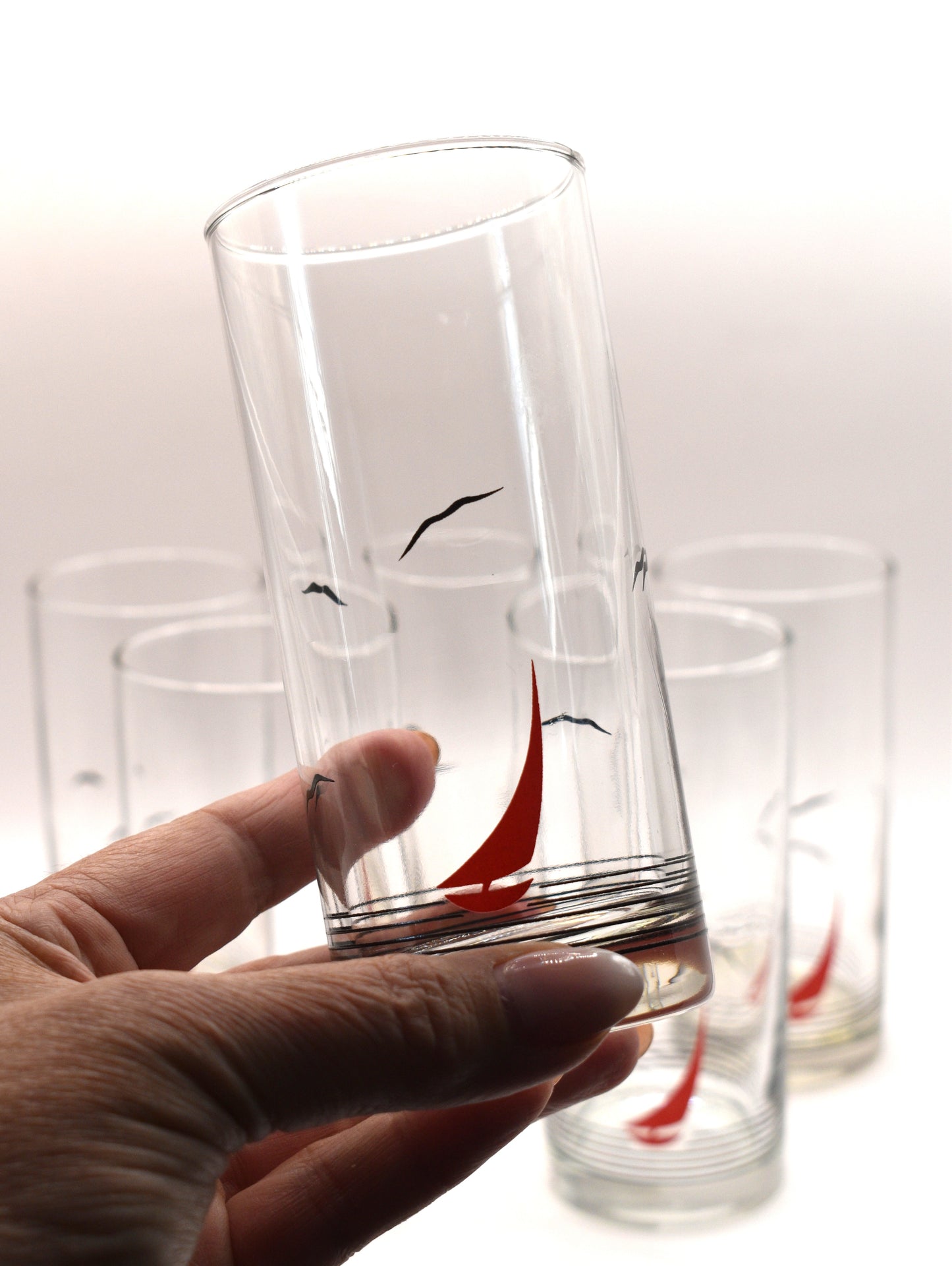 Glass pitcher and 6 matching tumblers with a nautical sailboat design.