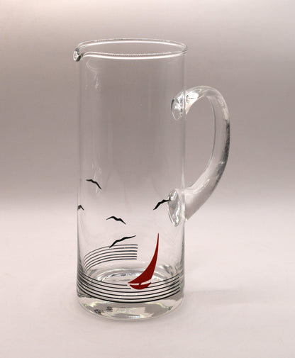 Glass pitcher and 6 matching tumblers with a nautical sailboat design.